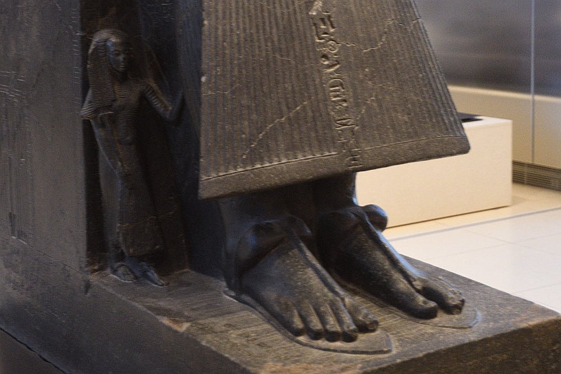 110_MAK_5827.jpg - Ramesse II ebbe un numero enorme di figli: tra i 48 e 50 figli maschi e tra le 40 e 53 figlie femmine. Nella statua è rappresentato il figlio Amonherkhepeshef primogentito e quindi destinato alla succesione, ma concepito con la regina Nefertari, ma non regnò mai perchè morì a circa 40 anni, per un colpo in testa, prima del padre.